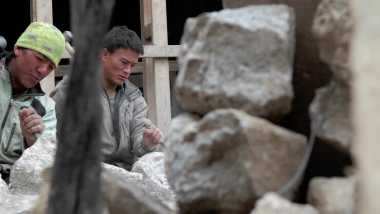 Pan of stone masons chiseling