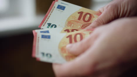 hands counting small savings indoors closeup. unknown man calculating euro bills