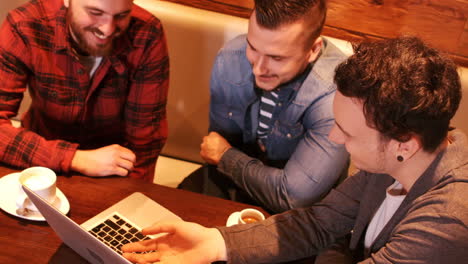 friends using laptop while having coffee