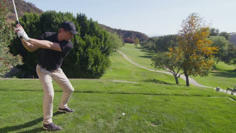 a golfer takes a swing on a golf course 2