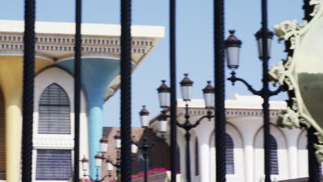 A-royal-seal-at-the-fence-and-Al-Alam-Palace,-Muscat,-Oman,-medium-shot-pan-left