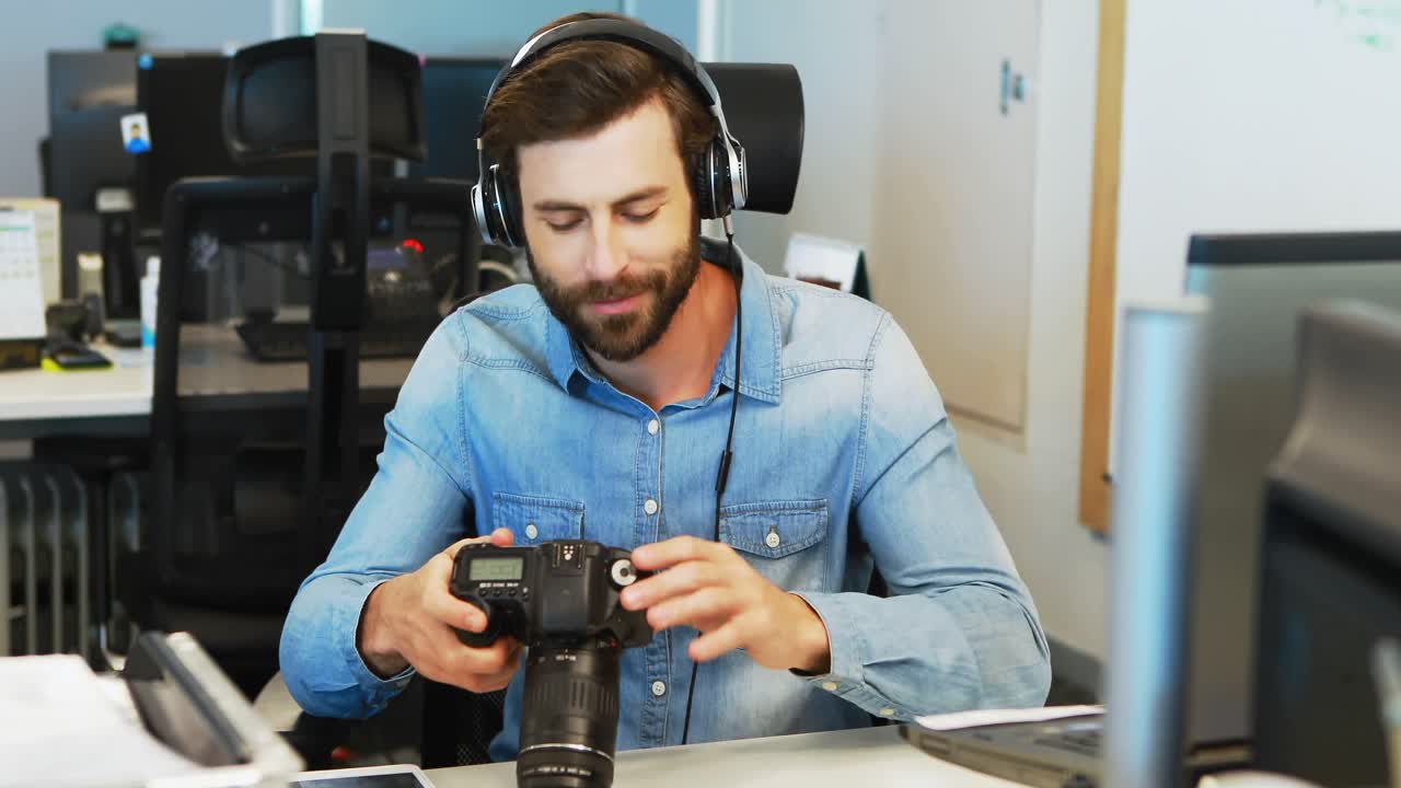 diseñador gráfico masculino con auriculares usando la cámara