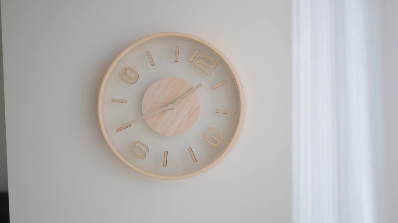 Minimalist Wooden Wall Clock Hanging on a White Wall