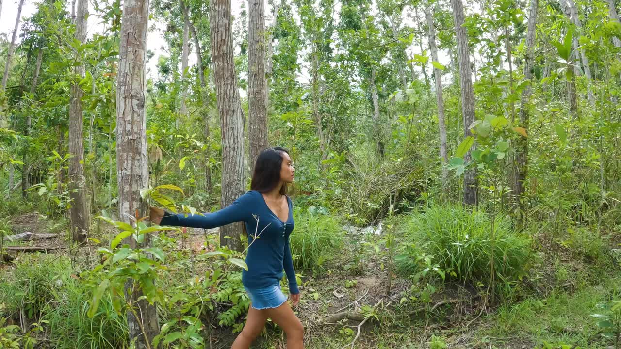 Asian Girl With Long Black Hair Walking Through Tropical Dense Forest. Tracking Shot