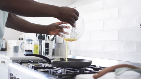 african american husband is pouring batter into a pan