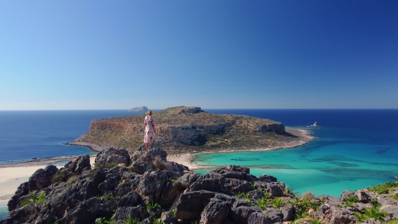 Woman observing beautiful white sand beach with turquoise water. Sunny summer day. Paradise. Crete, Greece