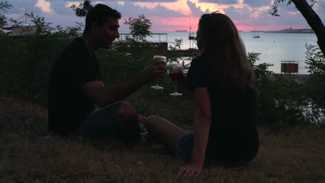 couple enjoying sunset by the sea with wine