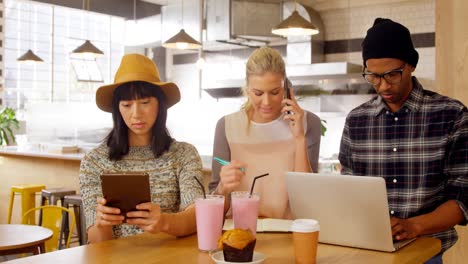 Führungskräfte-Nutzen-Mobiltelefon-Und-Laptop-Am-Tisch-4k