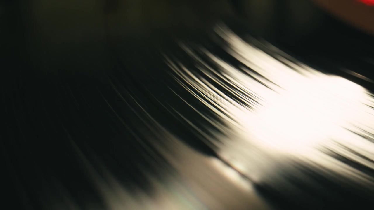 Primo piano di solchi di dischi in vinile che girano con riflesso della luce