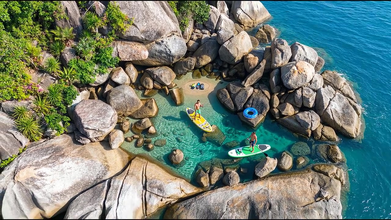 Teman-teman menjelajahi garis pantai berbatu selama aktivitas kebugaran dan petualangan luar ruangan