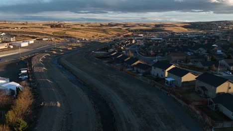 Aerial-shot-of-an-irrigation-levee-behind-suburban-houses-in-Eastern-Washington