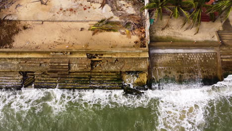 Vista-Aérea-De-Arriba-Hacia-Abajo-De-La-Marejada-Ciclónica-En-La-Costa-De-La-Playa-Tropical-Con-Palmera-Destruida-Por-El-Tifón-Durante-La-Temporada-Del-Monzón