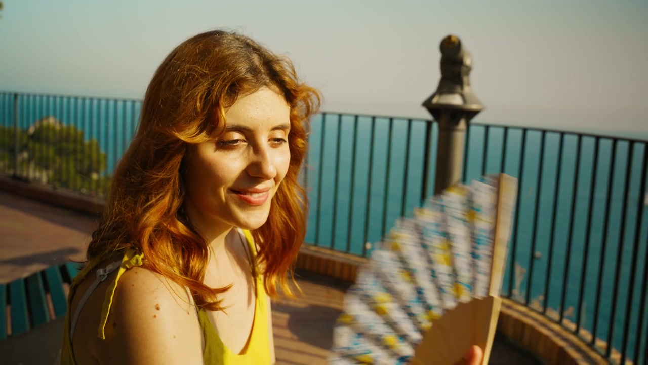 Woman with a fan and a yellow dress enjoying the sun on the island of Capri