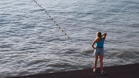 mujer mirando el agua desde un muelle