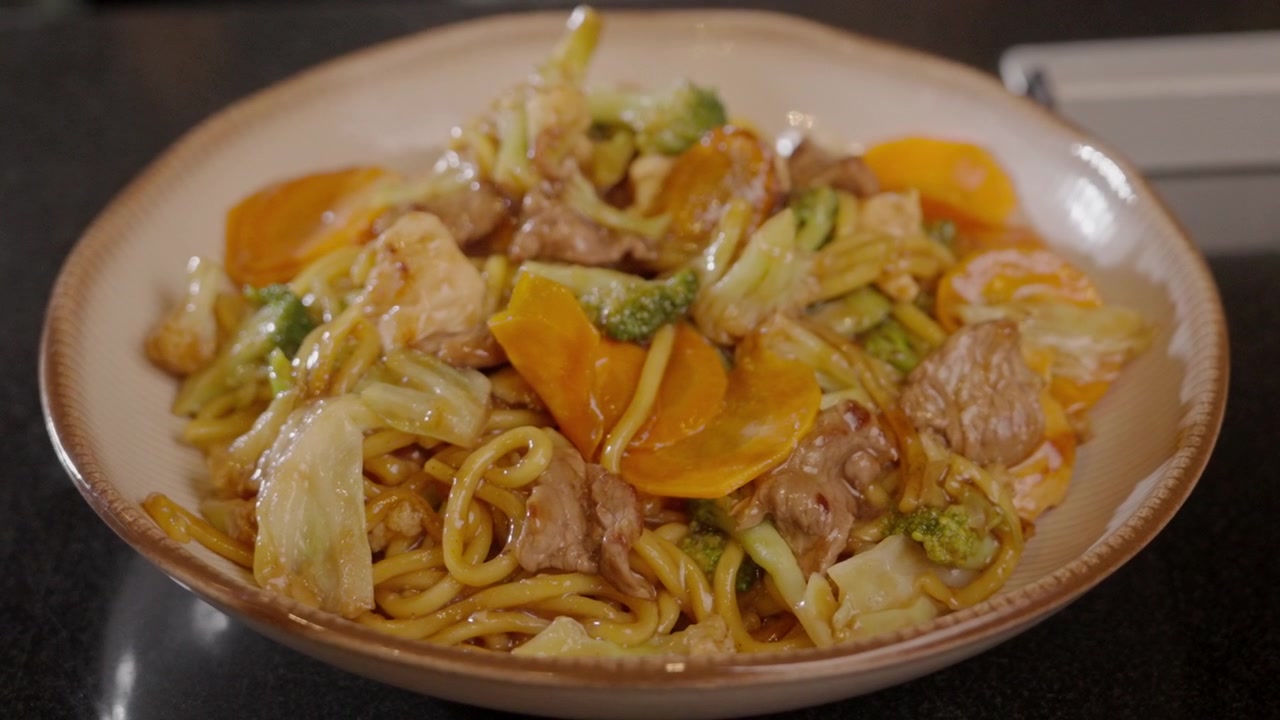 Foto close-up mi yang disajikan dengan sayuran dan daging dalam mangkuk.