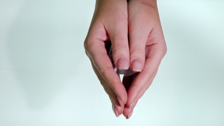 Mani con la scritta Aiutami su sfondo bianco.