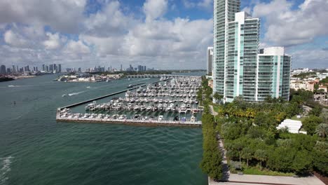 Drone-clip-moving-towards-Miami-Marina,-showing-rows-of-luxury-yachts,-tilting-downwards-to-focus-on-a-row-of-boats-and-catamarans