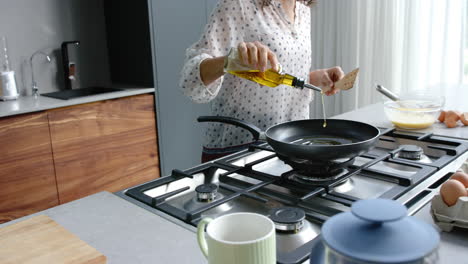 happy biracial couple cooking and preparing breakfast in kitchen, slow motion