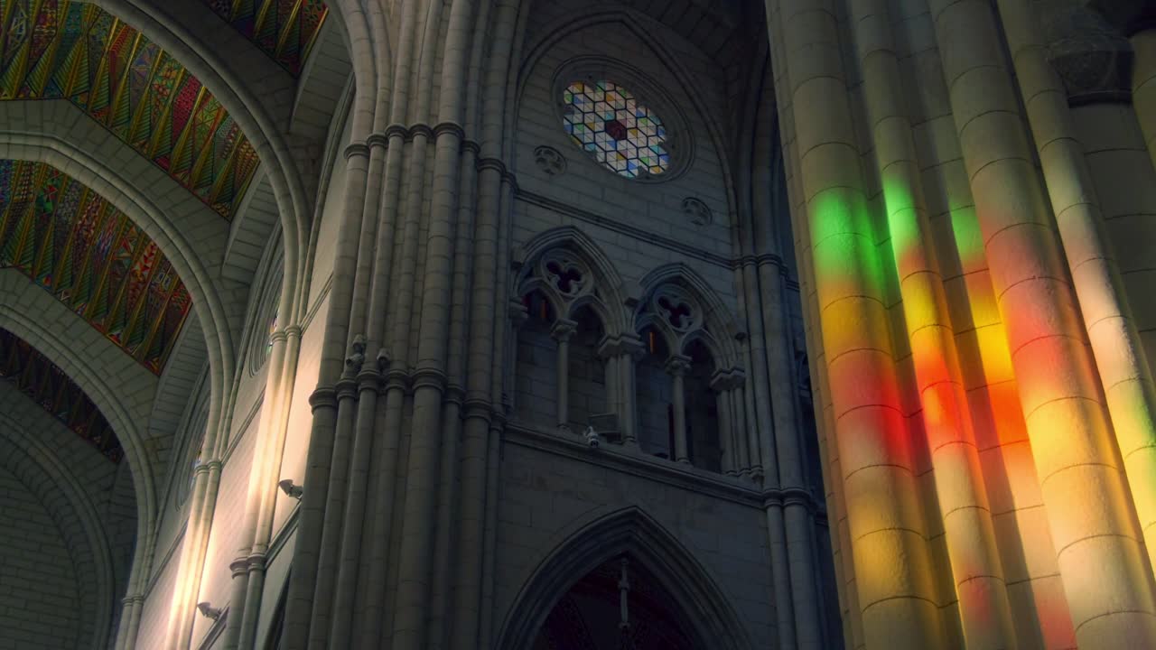 sunlight falls trough stained glass inside la almudena cathedral in madrid. slow camera movement