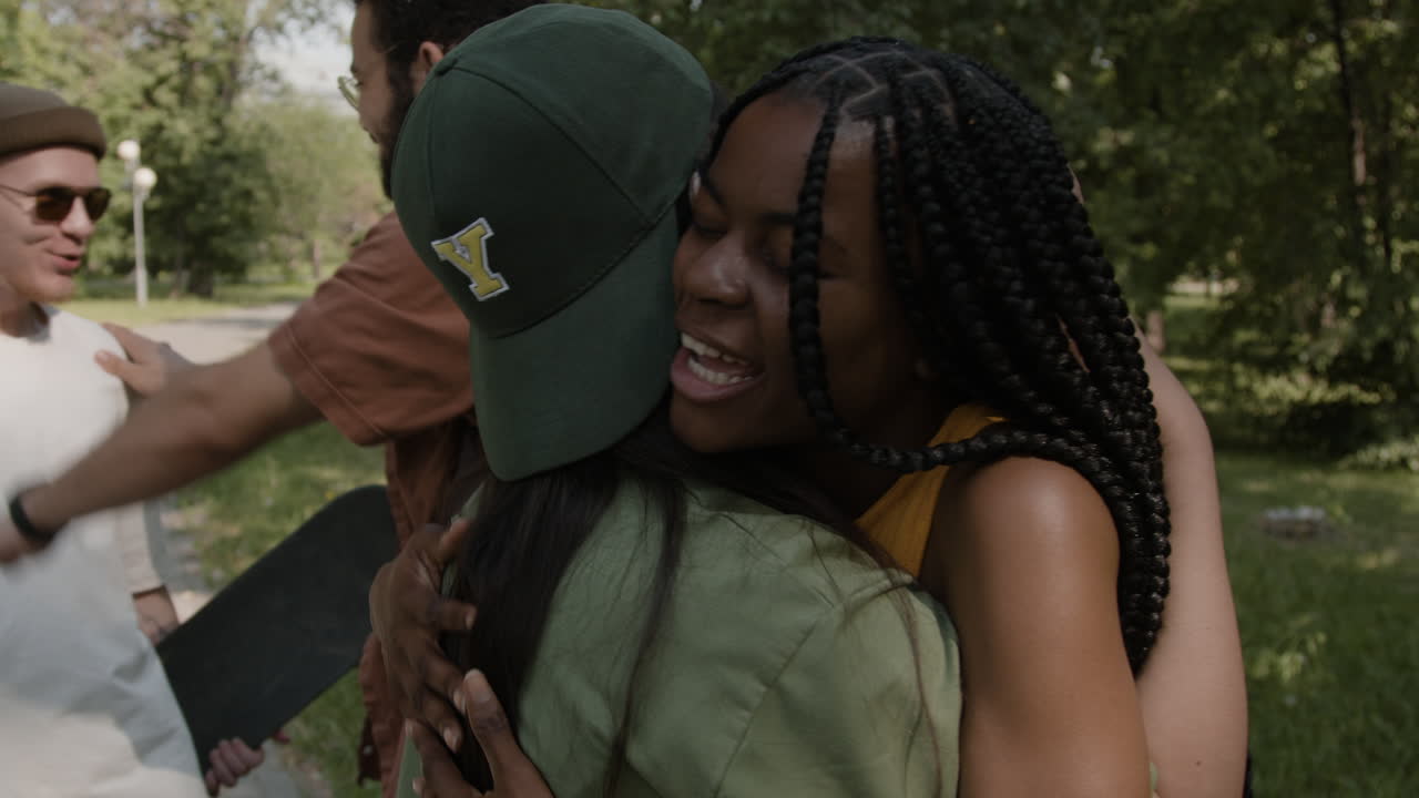 Friends greeting and hugging in a park