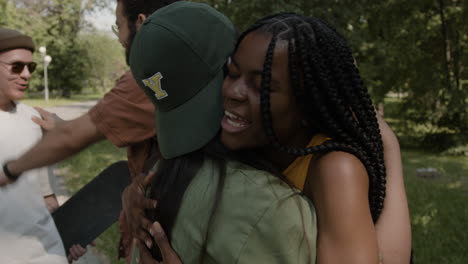 friends greeting and hugging in a park