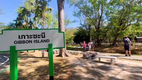 people walking near gibbon island sign