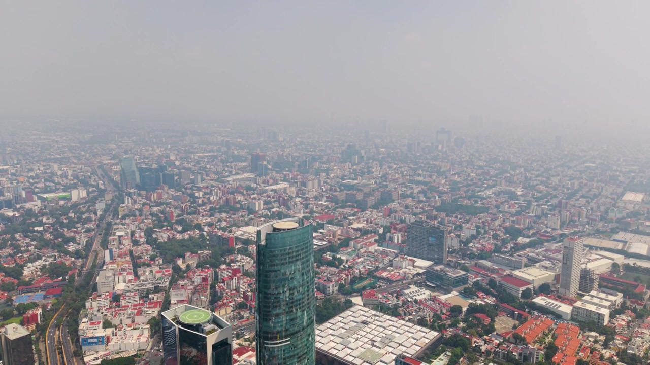 CDMX'te sisin içinden yükselen bir şehir kulesinin havadan görünümü