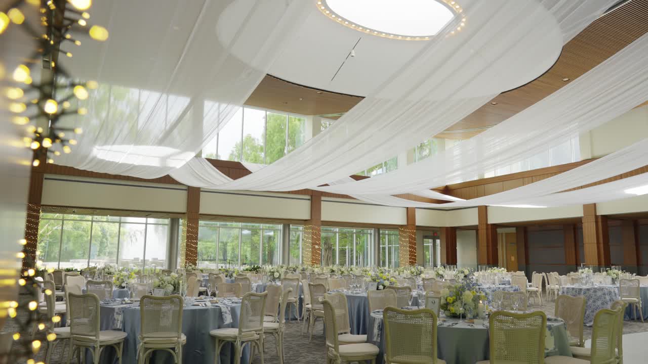 Opulent luxurious wedding banquet hall with light linen ceiling decoration hung over the venue