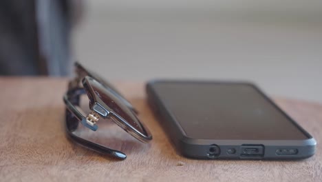 sunglasses and smartphone on a wooden table