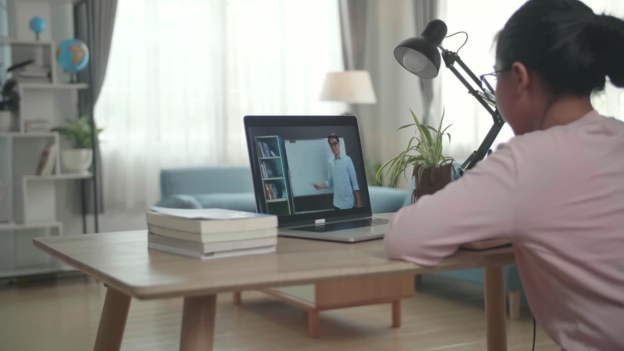 Teen Girl Student Distance Learning With Online Teacher On Computer Screen. Web Tutor Gives Remote Class Teaching Teenage Pupil E-Learning From Home
