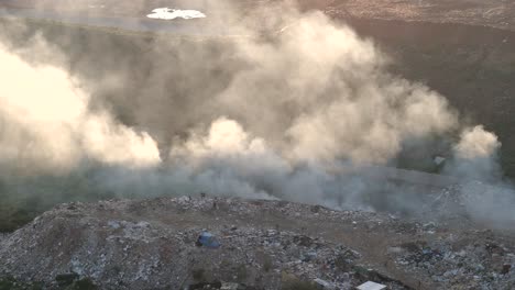 powerful 4k aerial footage, a static drone shot captures the disconcerting scene of waste being burned on the outskirts of a rural south african township