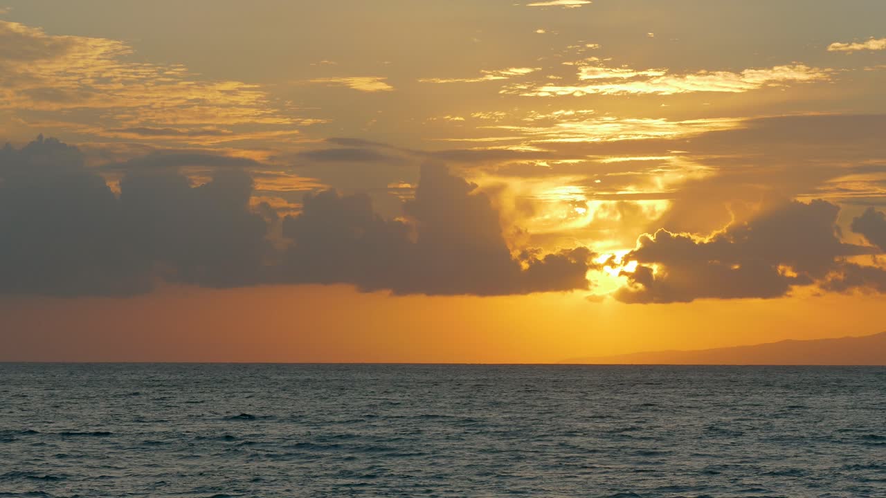 극적인 구름과 함께 바다 위에 해가 지는 것