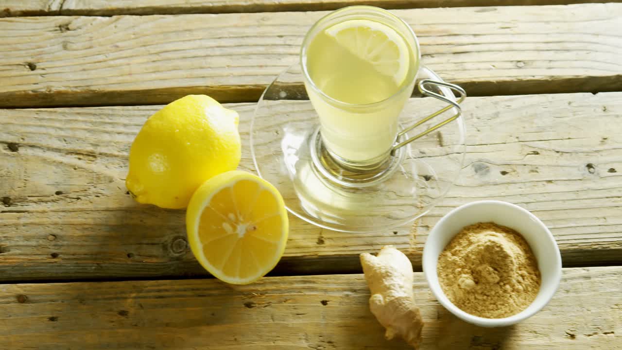 Tè al limone con zenzero in polvere su tavolo di legno 4k