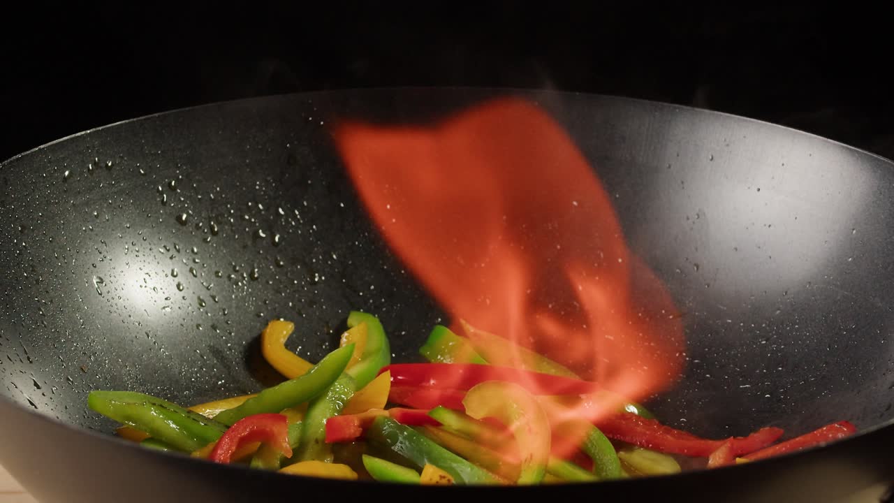 Stir-frying colorful peppers in a wok