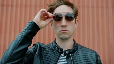 hombre elegante con chaqueta de cuero y gafas de sol