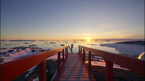 view over walkway towards sunset over sea of ilulissat icefjord