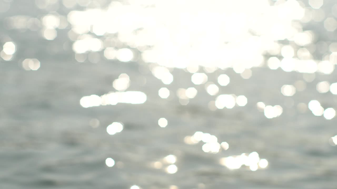 brilla y brilla la superficie del agua del océano, el mar, el lago o el estanque. enfocar y desfocar hacia atrás. video en bucle.