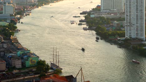 boats in chao phraya river at sunset in bangkok city, thailand.