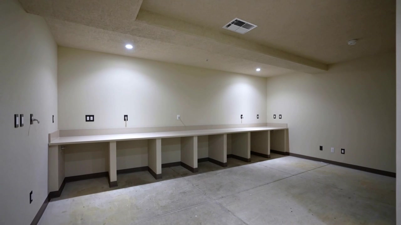 Lenta panoramica della telecamera attraverso la lavanderia, che mostra un lungo piano di lavoro integrato, prese elettriche, termostato.