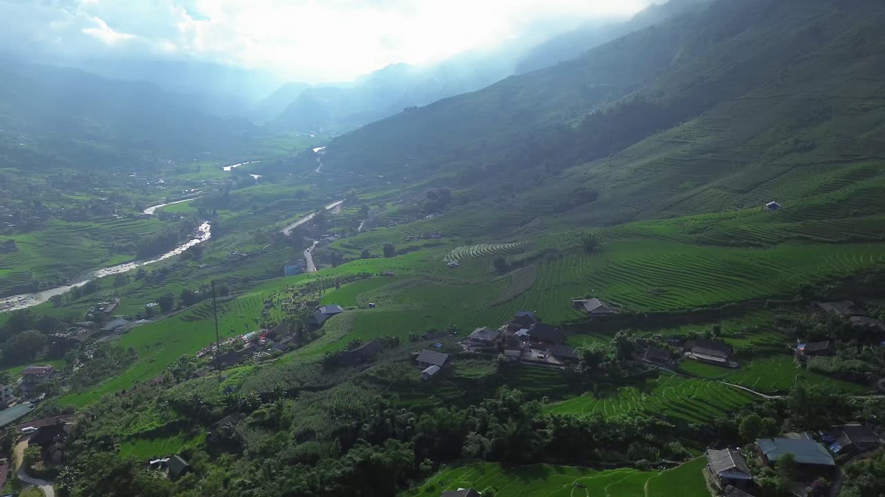 Pan left reveals sweeping rice terraces and small village rooftops below. In Lao Cai, Sa Pa