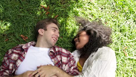 happy multiracial couple lying on grass