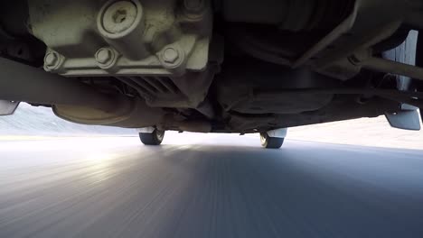 view from under a car while driving in iceland. road trip