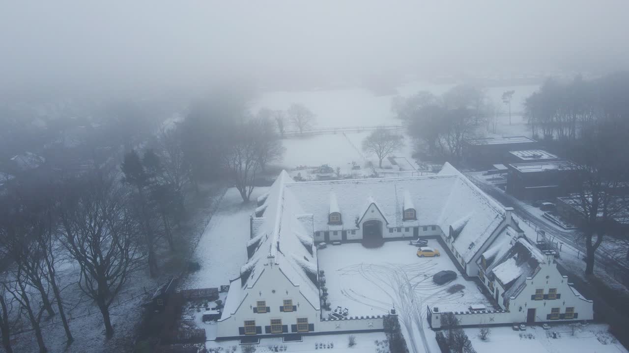 아름다운 눈에서 멀리 날아가는 무인 항공기는 겨울에 시골 네덜란드의 오래된 농장을 덮었습니다.
