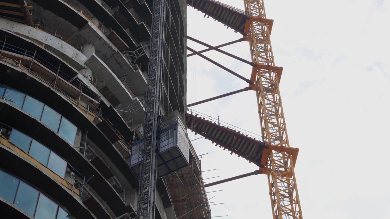 Construction Elevator Moving Up Side of Skyscraper
