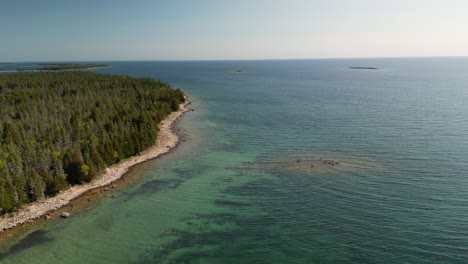 aerial ascent reveal of lake huron forested coastline, michigan