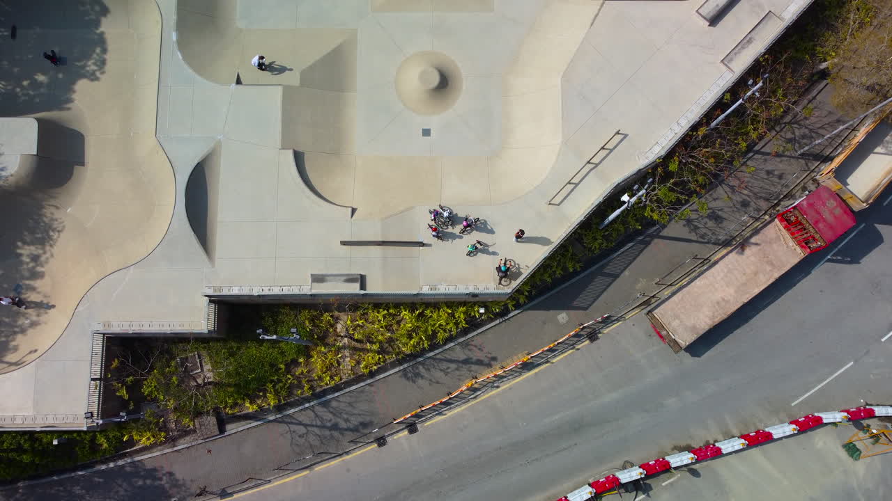 Drone 4K con vista a volo d'uccello inclinata su Skate Park di Hong Kong che mostra un ciclista BMX e uno skater