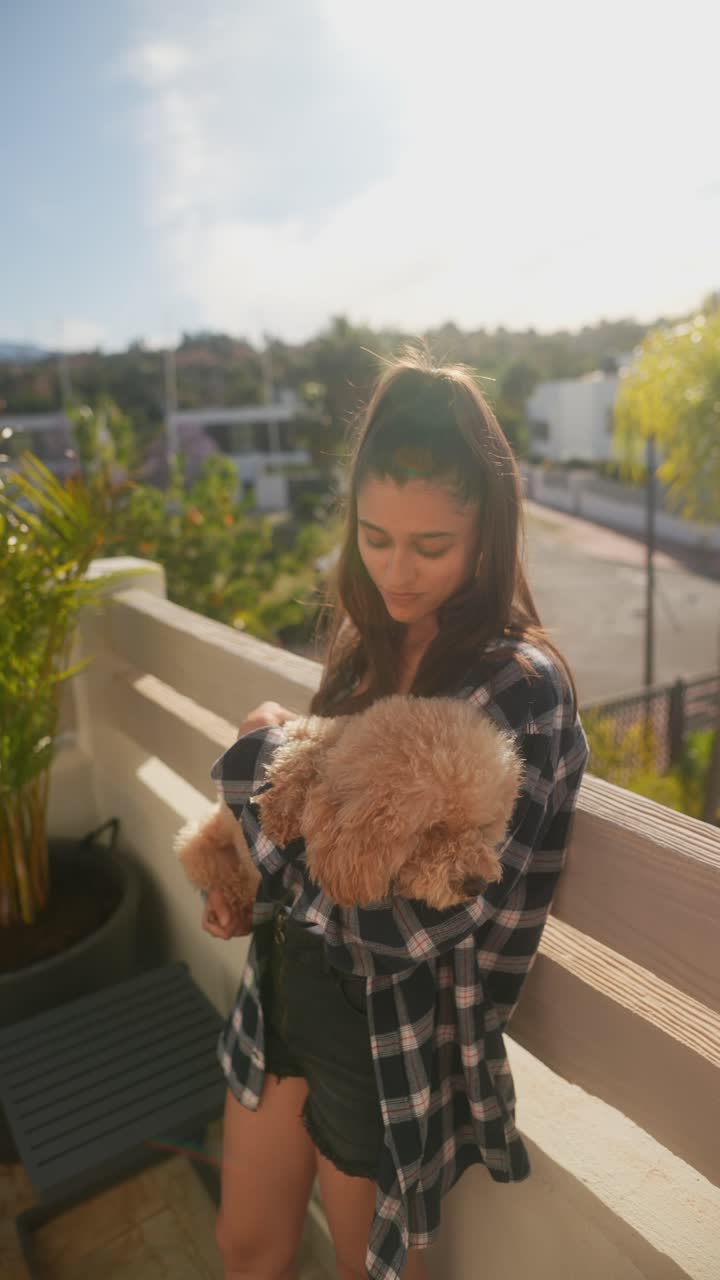 발코니 에 푸들 을 들고 있는 소녀