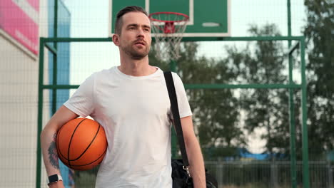 man holding basketball at outdoor court