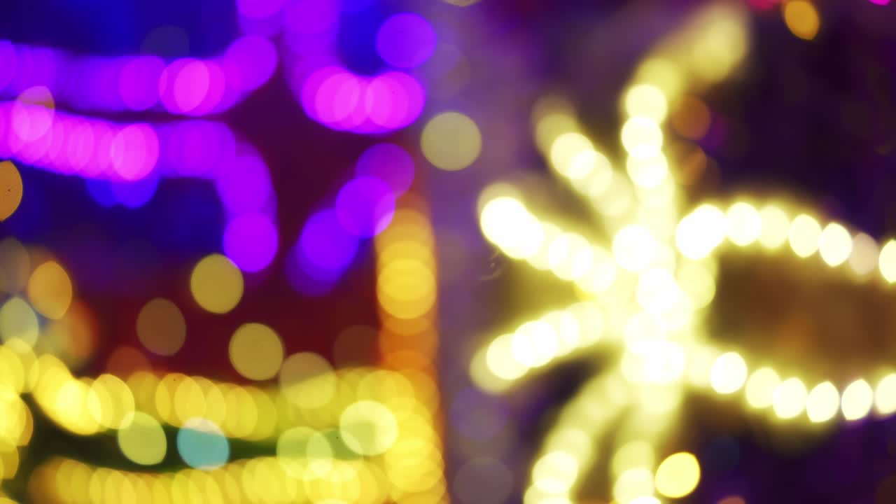 decoração de natal colorida e brilhante. decoração brilhante de néon em close-up na rua. feliz ano novo. celebração de feriados de inverno na cidade noturna. imagens 4k