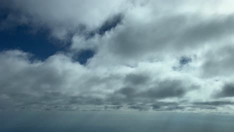 Die-Perspektive-Eines-Pliloten-Aus-Einer-Jet-Kabine,-Während-Er-Knapp-Unter-Einer-Schicht-Dünner-Stratuswolken-Fliegt